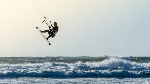 Foto de um homem praticando kitesurfe